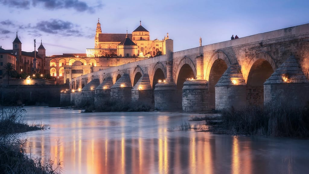 Panoramic view of Córdoba with the Roman Bridge and the Mezquita-Cathedral at dusk